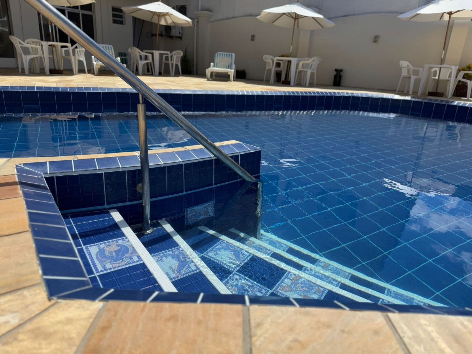 Escada e degraus da piscina com azulejos azuis