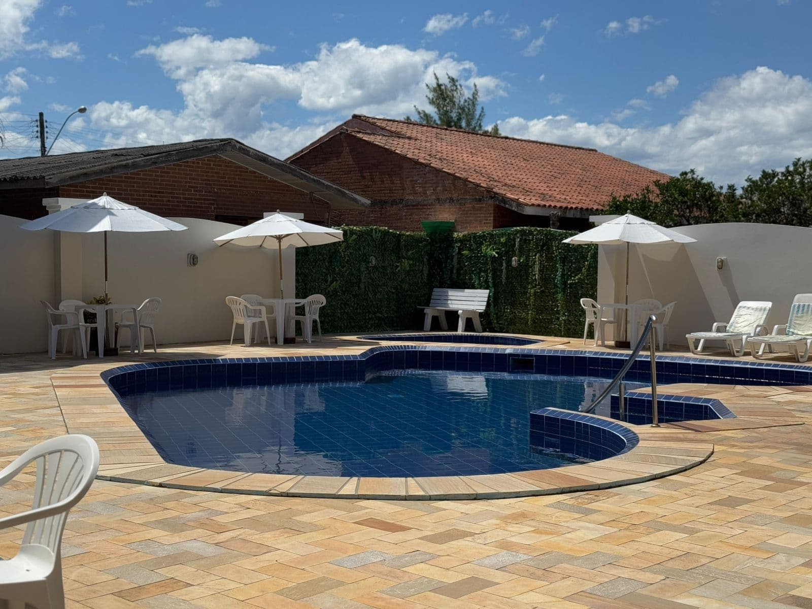 Piscina do Hotel Marazul sob céu azul, com guarda-sóis e espreguiçadeiras