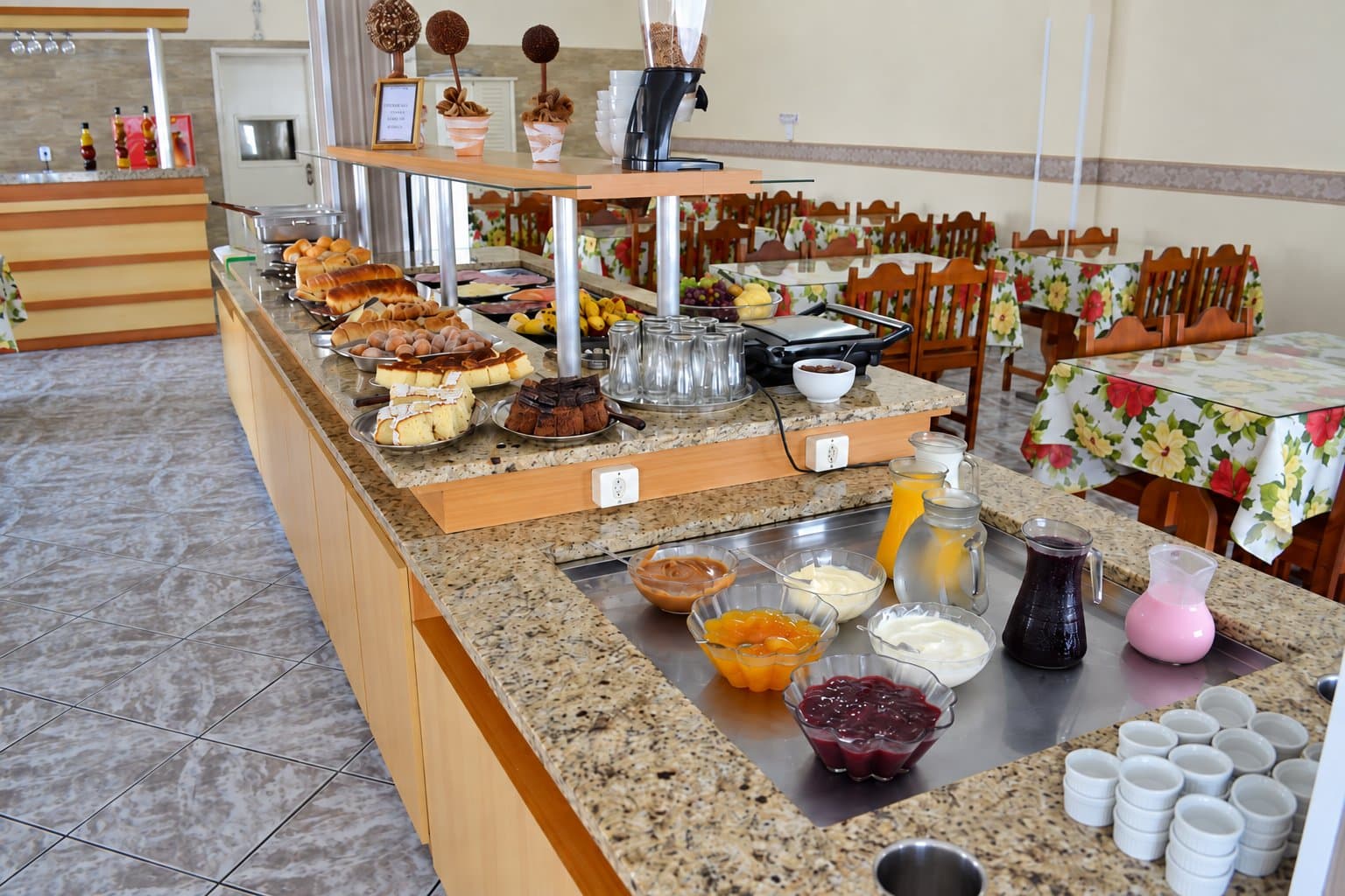 Buffet de café da manhã com frutas, pães, bolos e bebidas