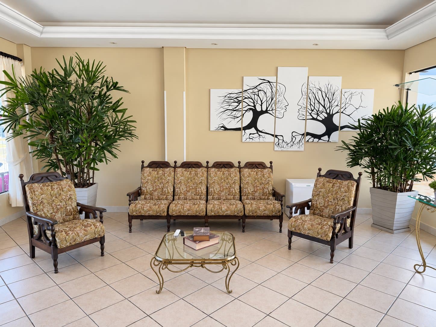 Sala de estar com sofás, poltronas e plantas